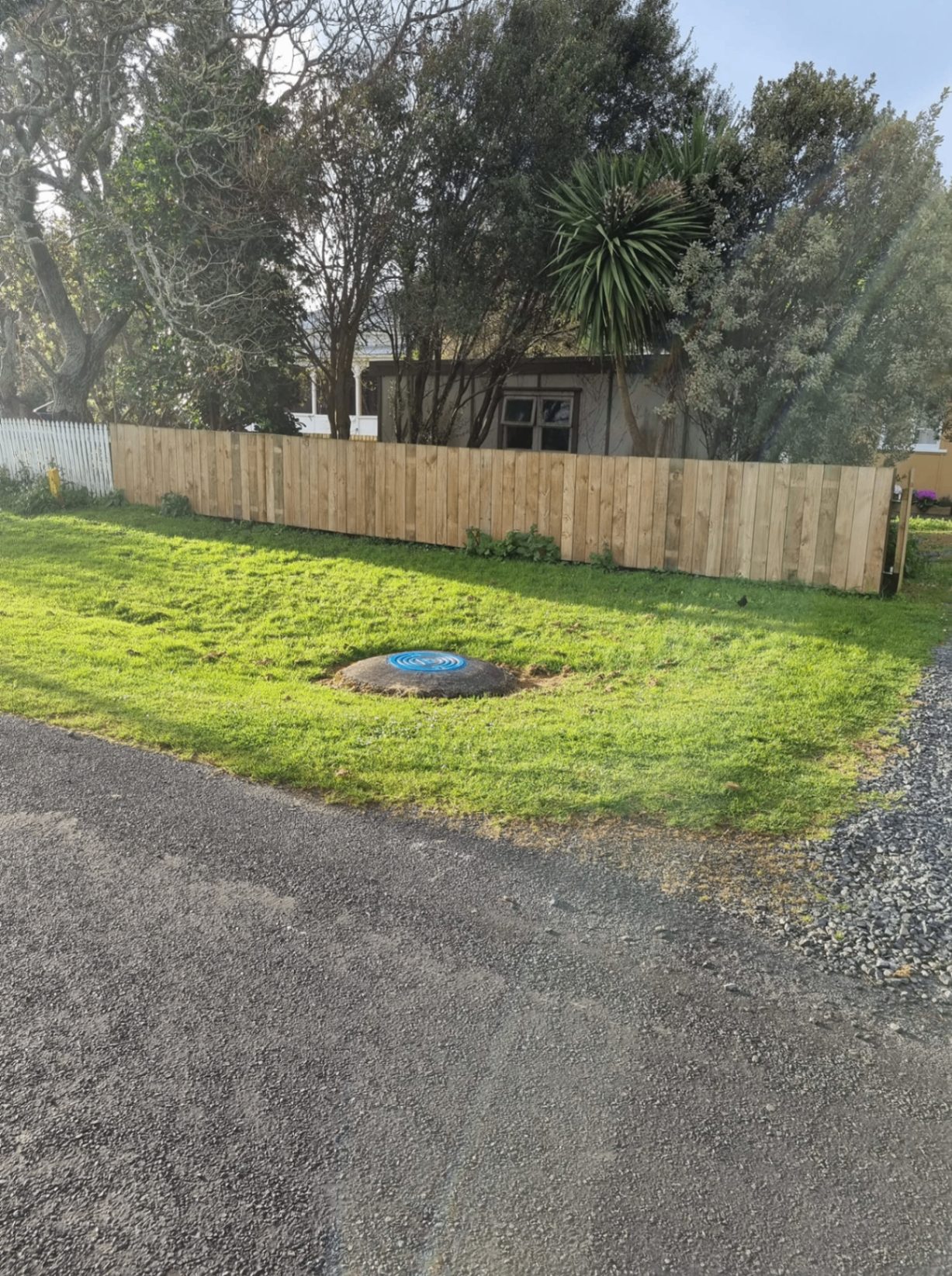 Completed residential timber boundary fence beside a lawn